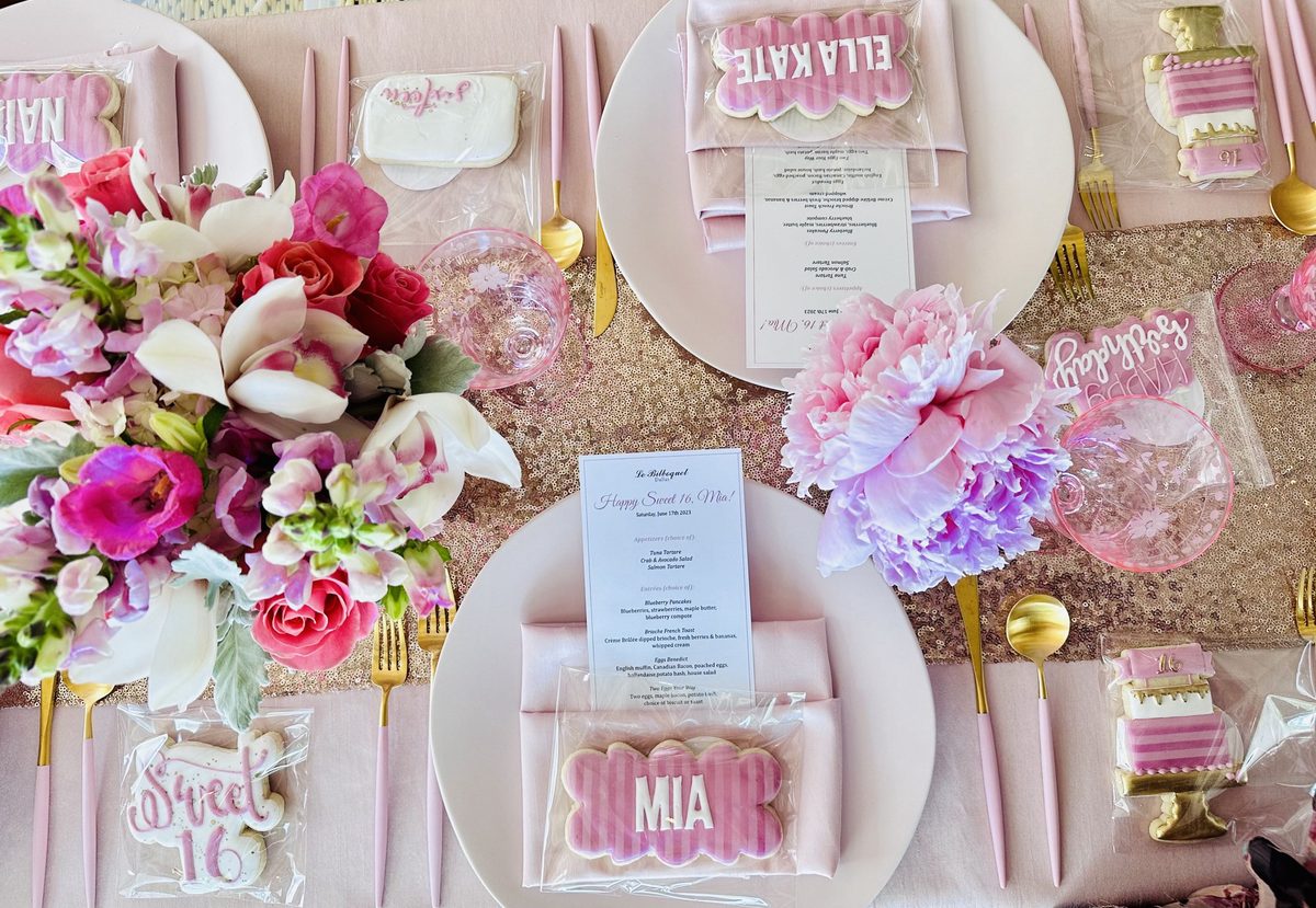 A place setting with custom cookies and a printed menu.